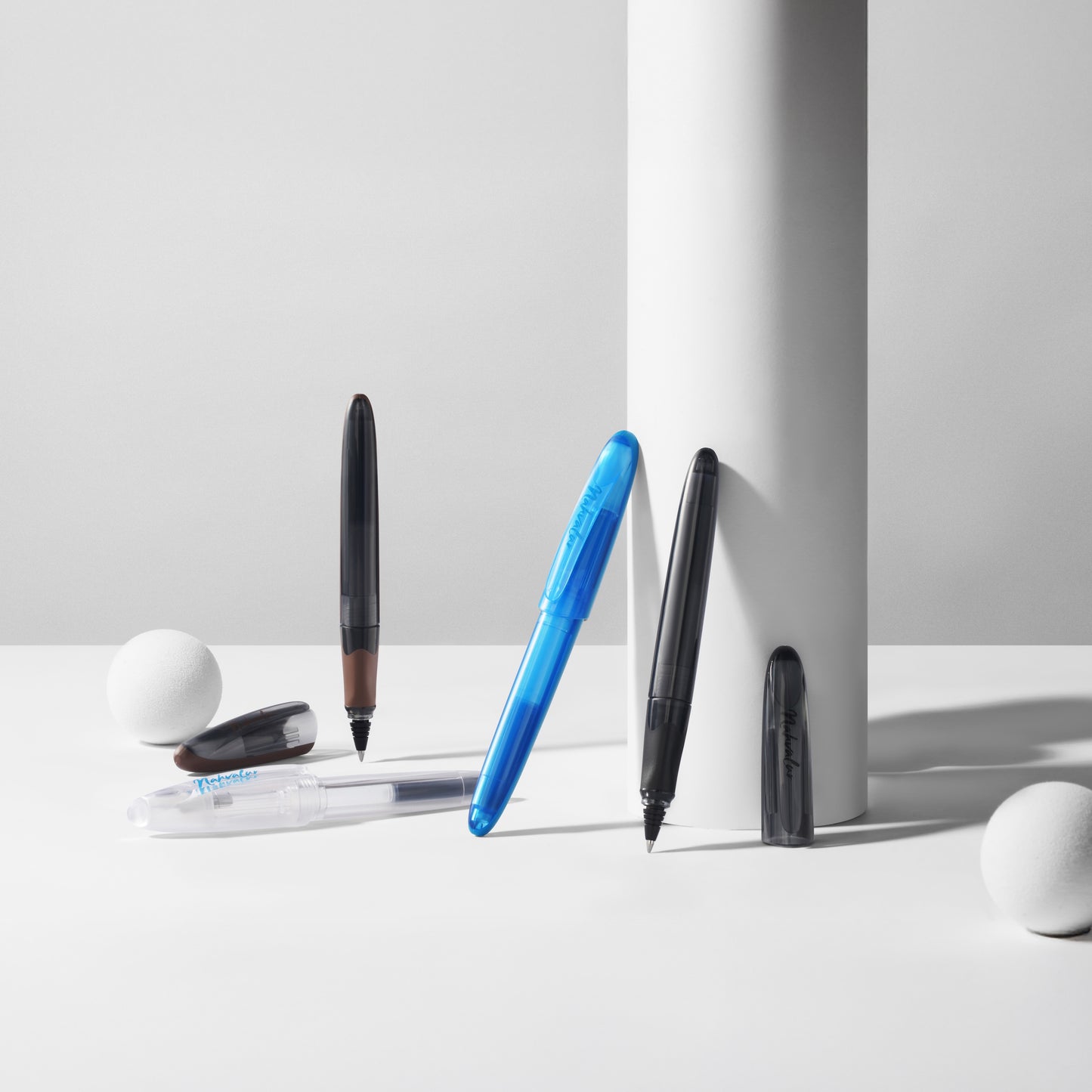 Set of pens and markers on a white surface with a gray background