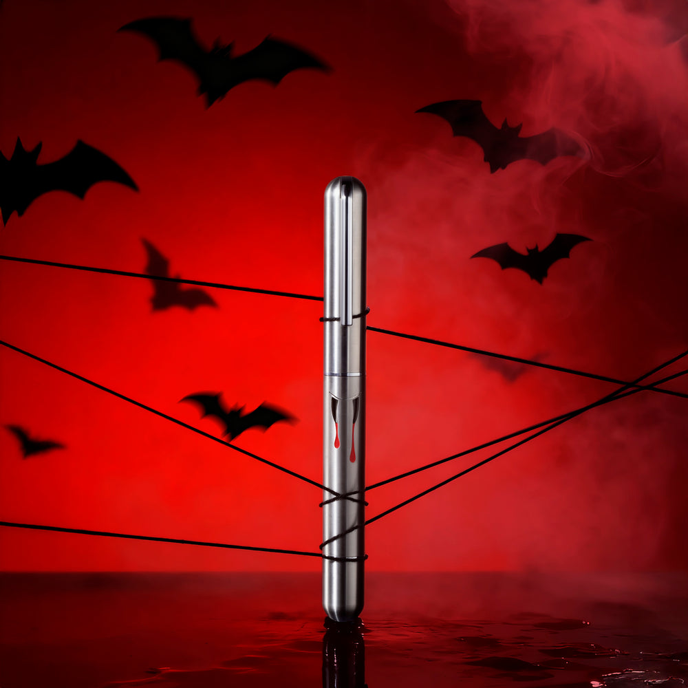 Silver pen with red liquid on a Halloween-themed background with bats and a red sky.