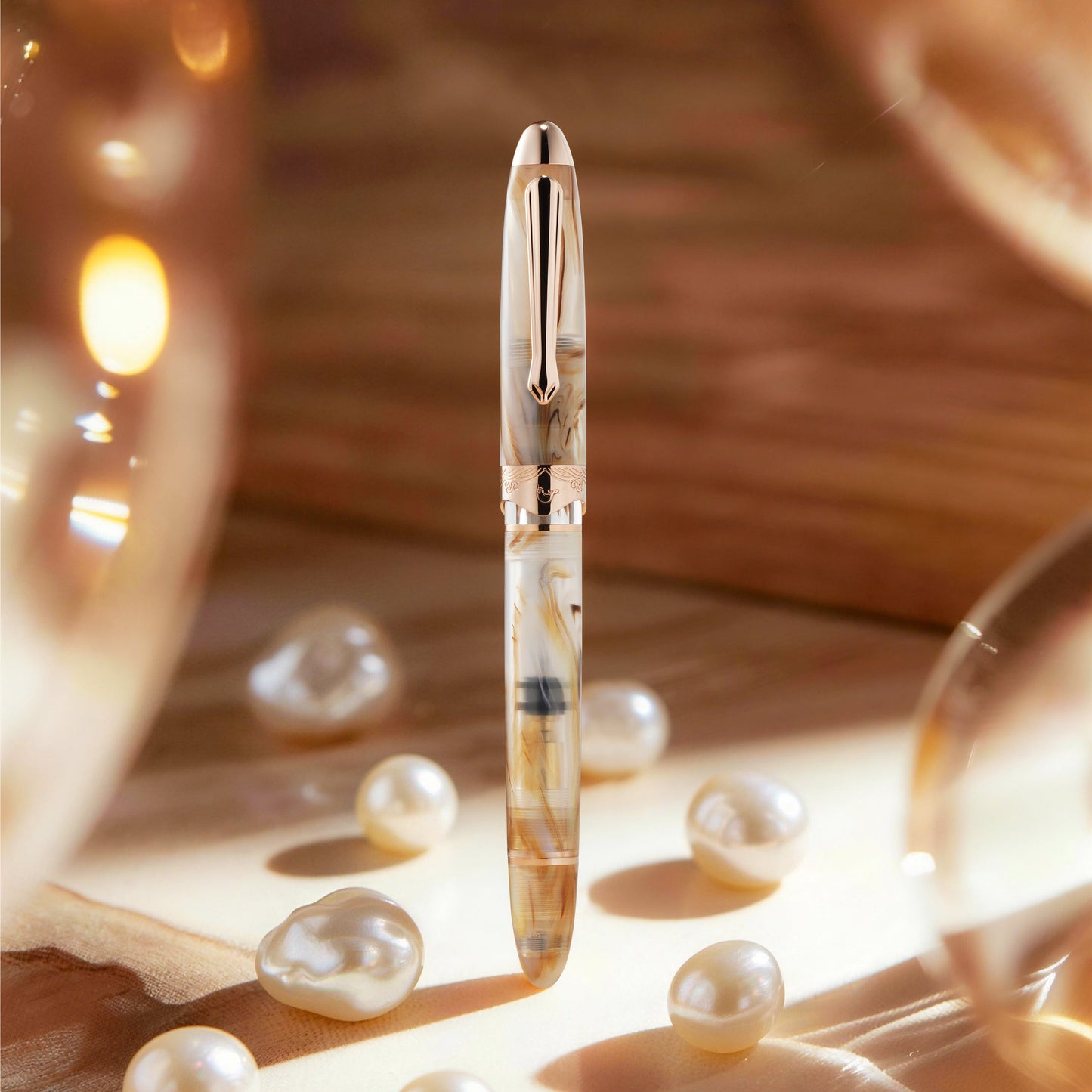 
                  
                    Rose gold pen with a decorative design on a wooden surface with pearls
                  
                