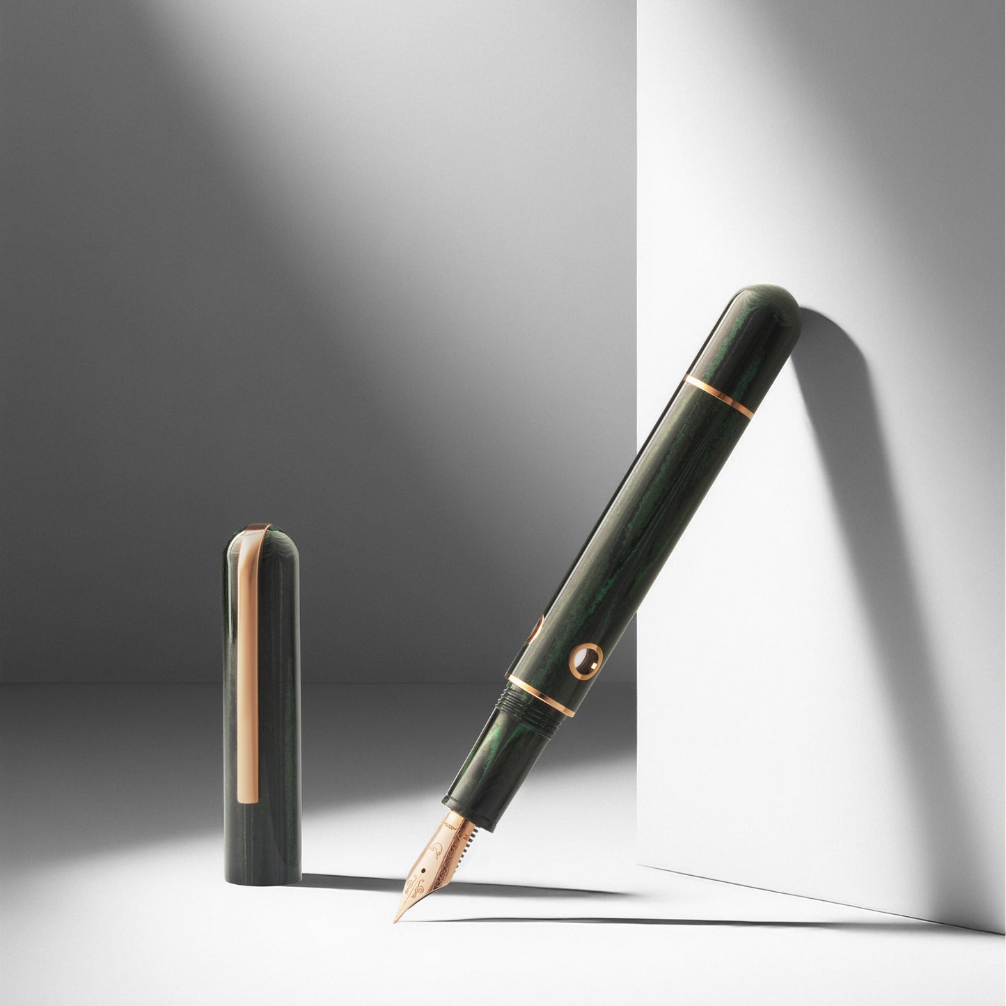 Green fountain pen with gold accents on a gray background