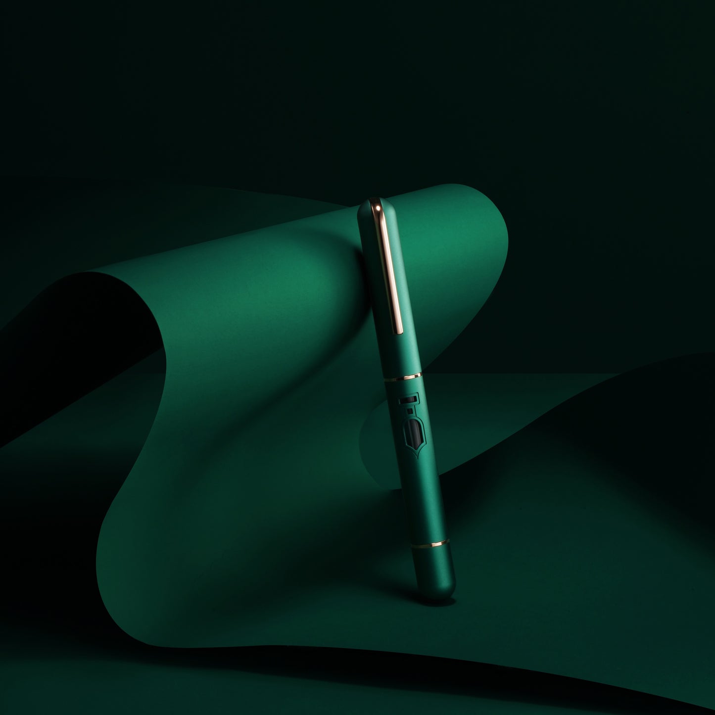 Green pen on a dark green surface with a black background