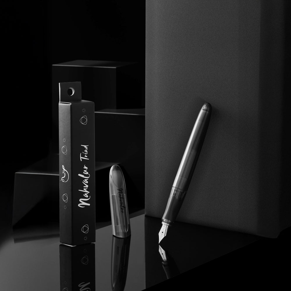 Fountain pen and ink cartridges with 'nahvalur Triad' branding on a dark surface.