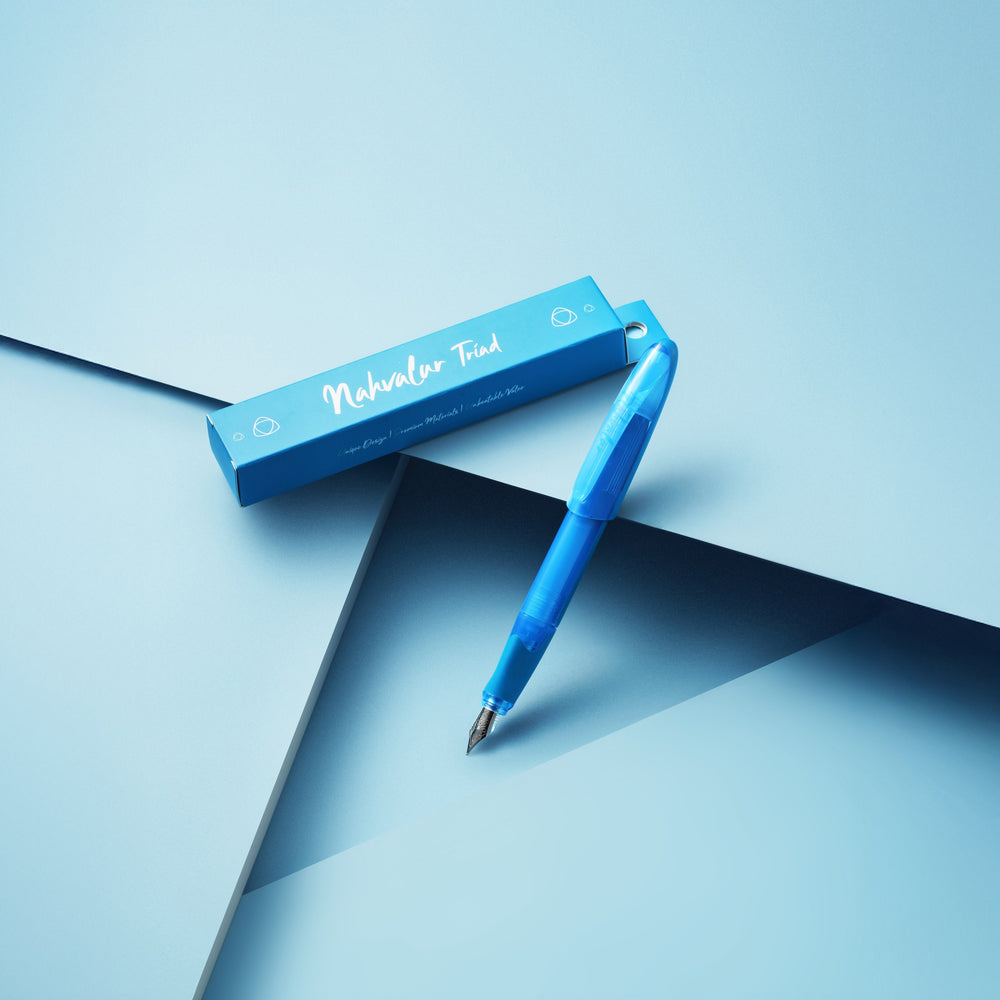 Blue pen and its packaging on a light blue background