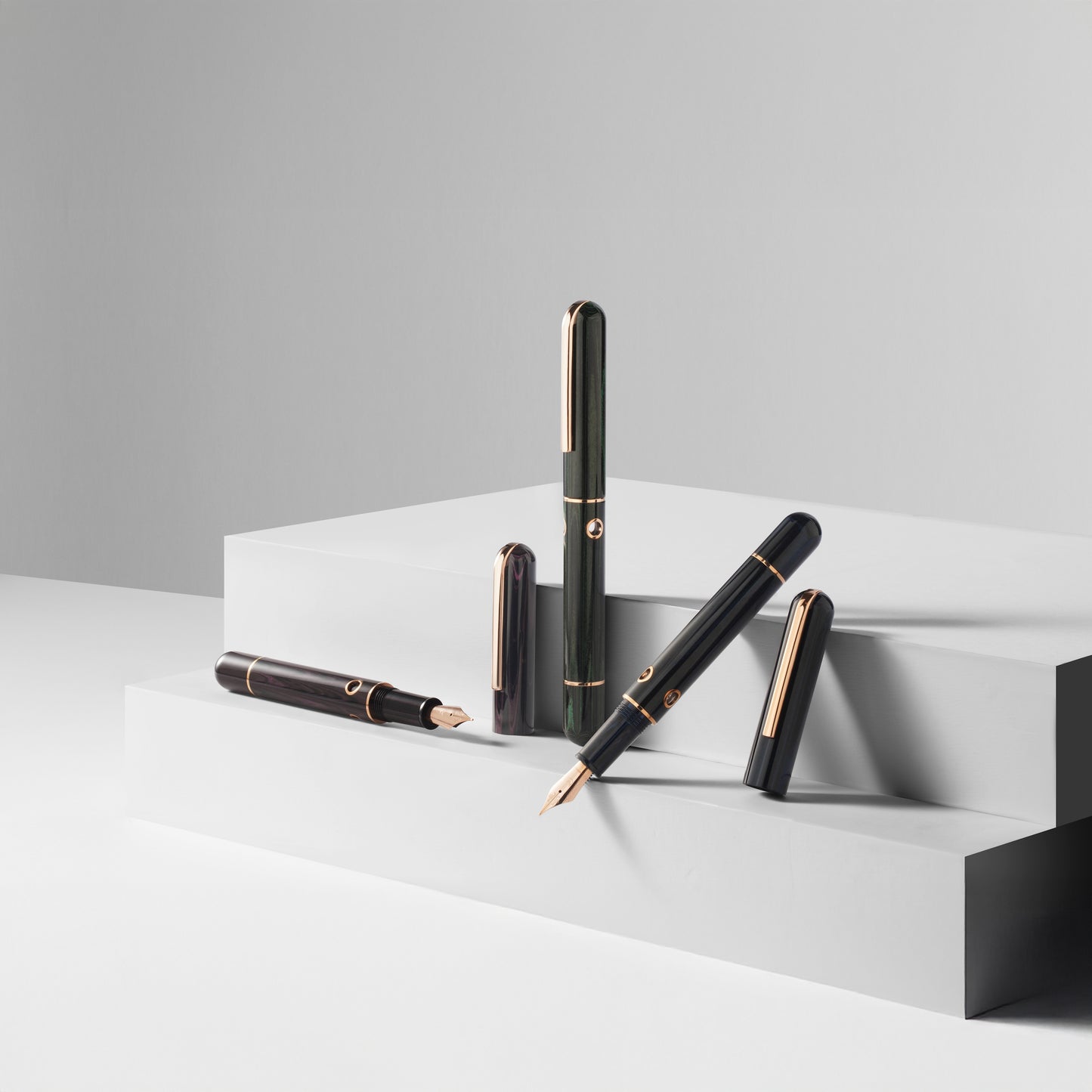 
                  
                    Set of pens on a white platform with a gray background
                  
                