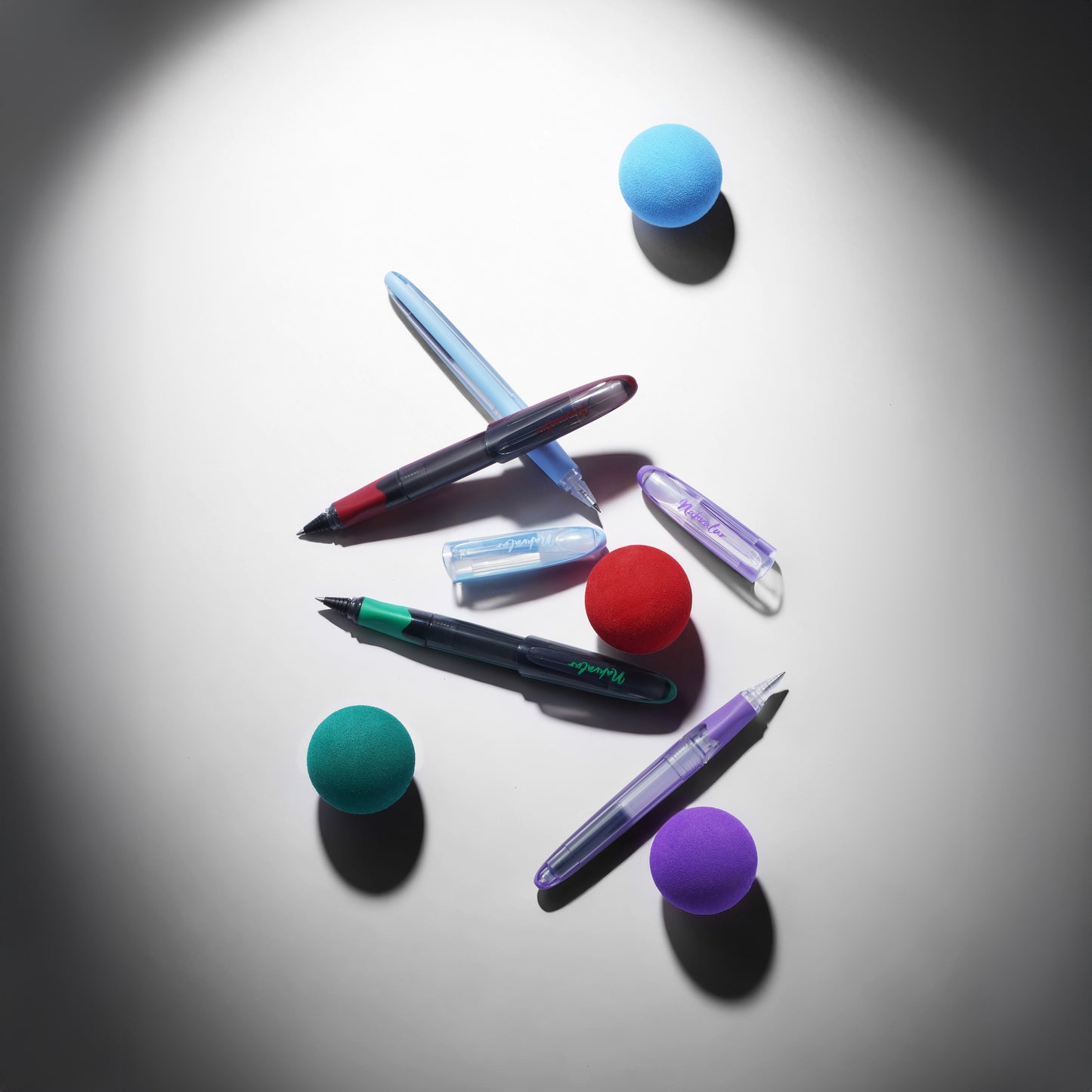 
                  
                    Colorful pens and markers with spherical caps on a reflective surface
                  
                